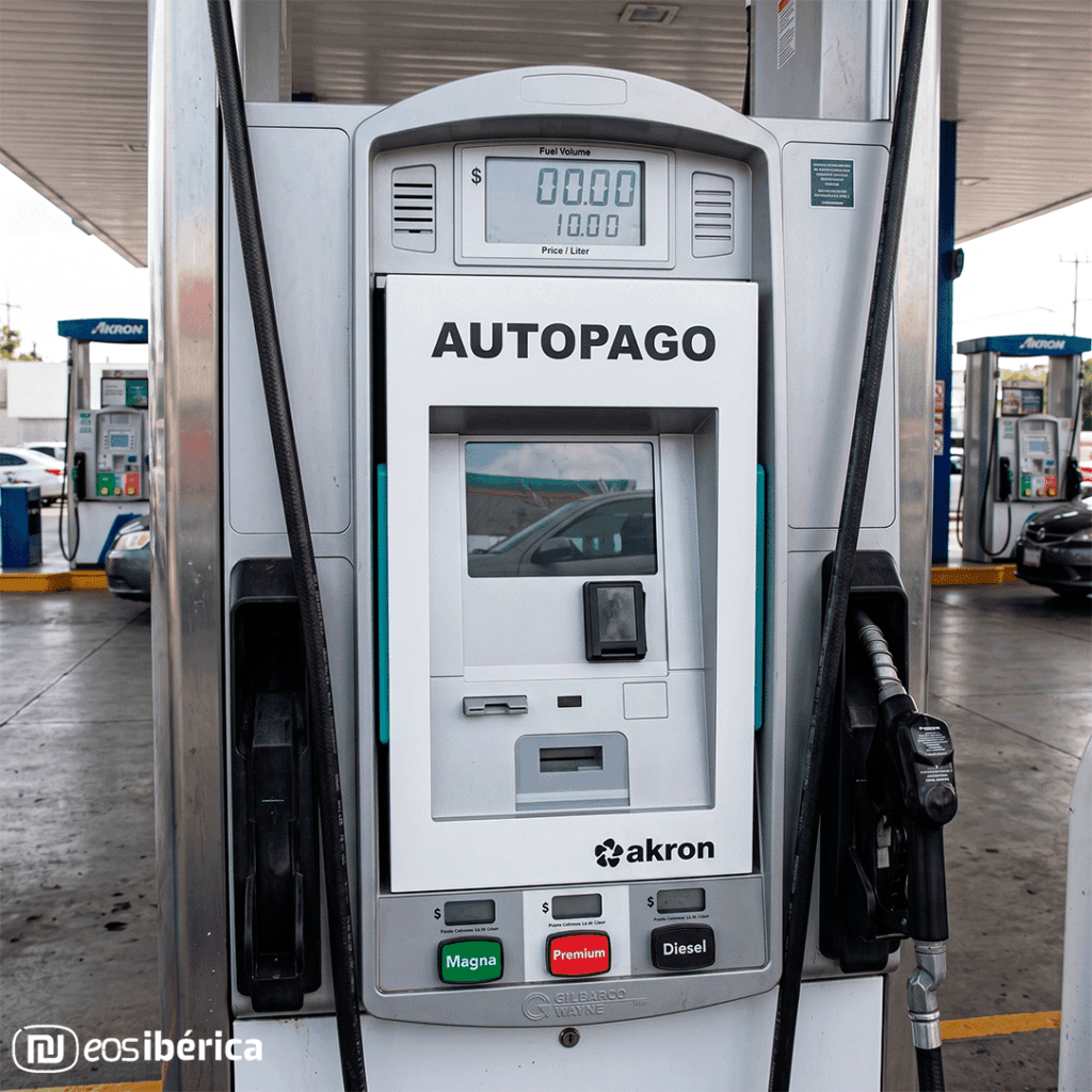 Fotografía realista y en primer plano del panel de control de un surtidor de gasolina. En el centro, está integrado nuestro terminal de autopago eAutopago Encastrable de color blanco que muestra claramente el texto 'AUTOPAGO' en la parte superior. El terminal incluye una pantalla, un lector de tarjetas y ranuras.