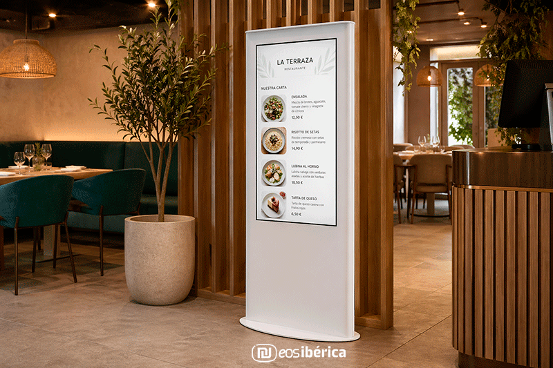 Tótem digital de interior en restaurante mostrando la carta en pantalla junto a la entrada.