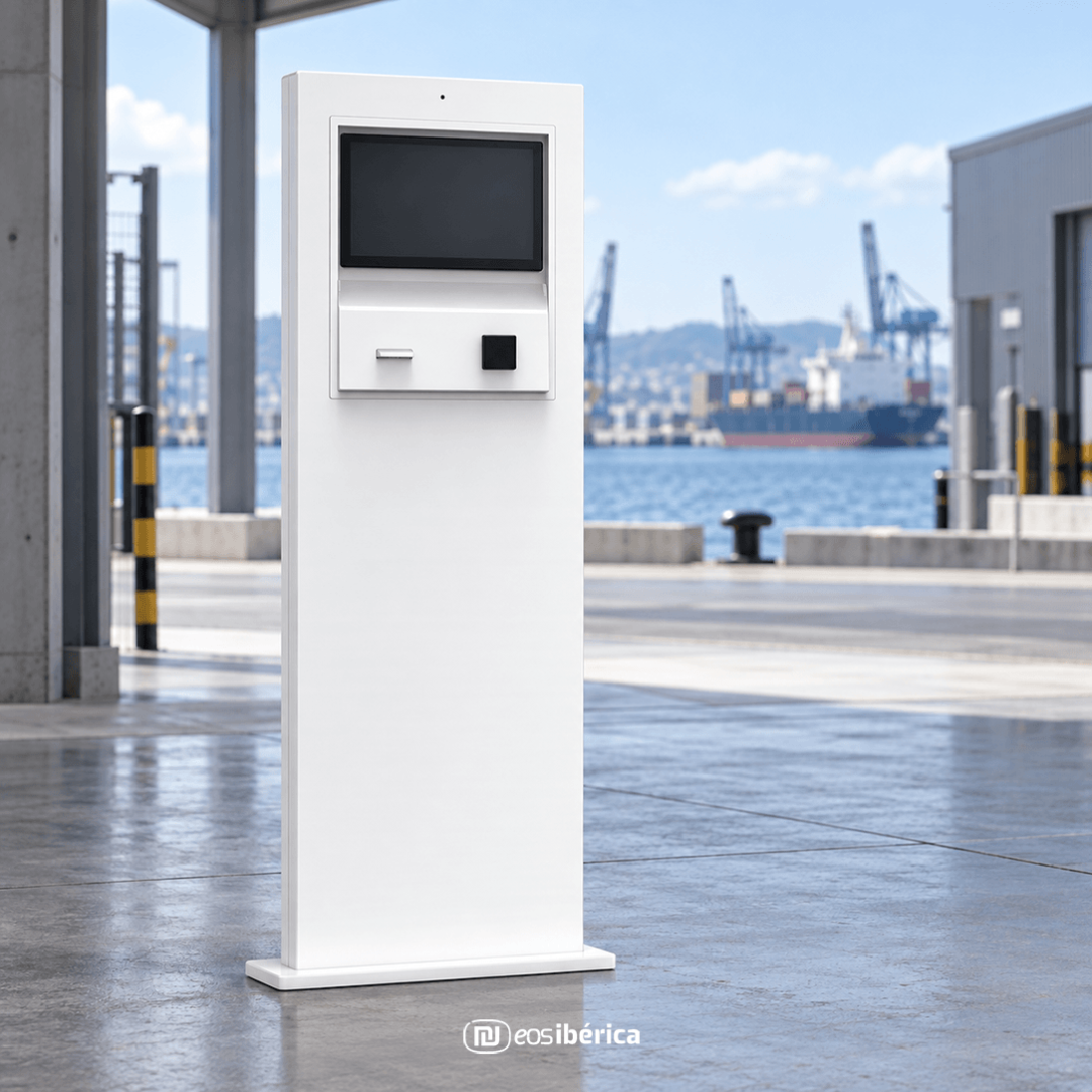 Terminal interactivo EOS Ibérica instalado en una zona industrial portuaria, con el mar y las grúas al fondo.